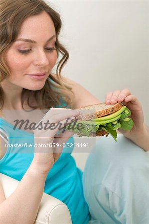Frau holding Vollkornprodukte Avocado und Brunnenkresse sandwich