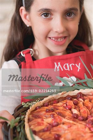 Girl holding freshly-baked apple and cranberry tart