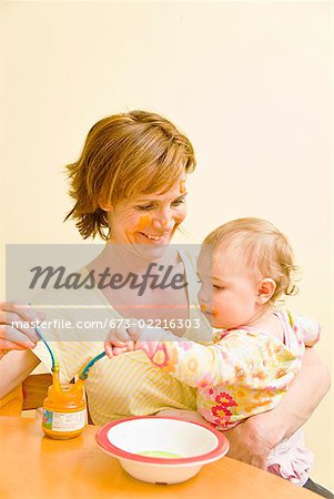 Mother feeding messy baby