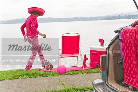 Woman in pink and Boston Terrier dog picnicking by bay