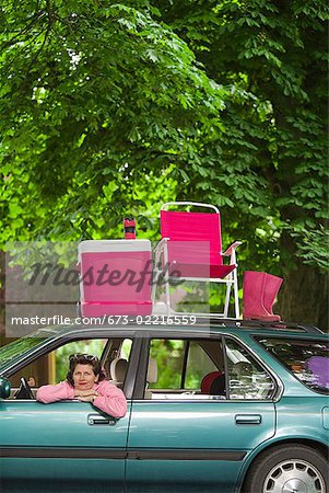 Femme assise dans la voiture avec pique-nique situé sur le dessus