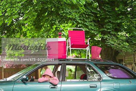 Femme assise dans la voiture avec pique-nique situé sur le dessus