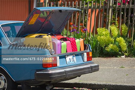 Coffre de voiture chargé avec valises colorées