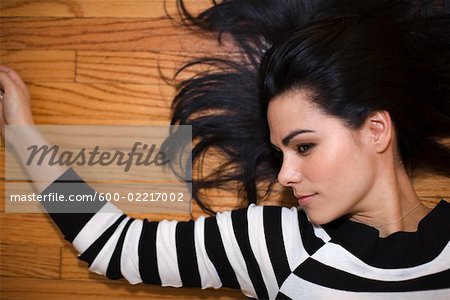 Jeune femme gisant sur le plancher de bois franc