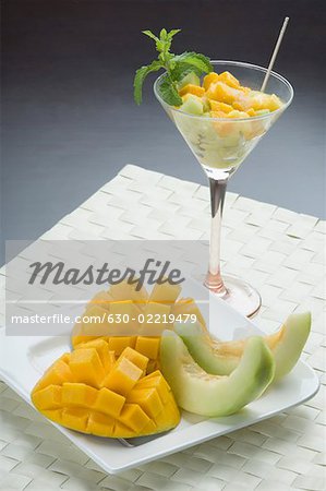 Gros plan des tranches de mangue et de tranches de melon dans une assiette