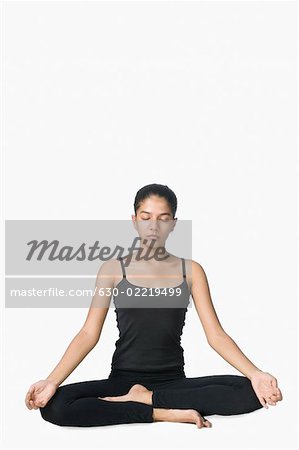 Junge Frau sitzt in einer Lotus-position