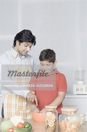 Young man helping his son in preparing food