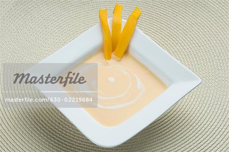 Bowl of cream with mango slices