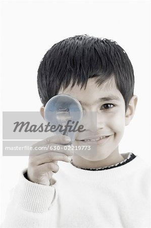 Portrait of a boy holding a light bulb