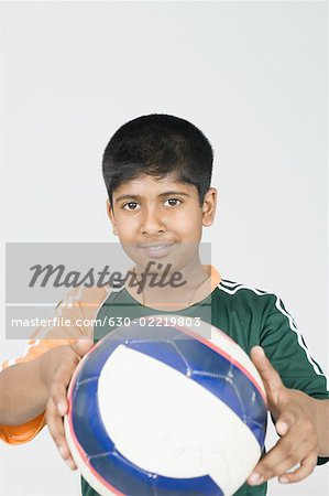 Portrait of a boy showing a football