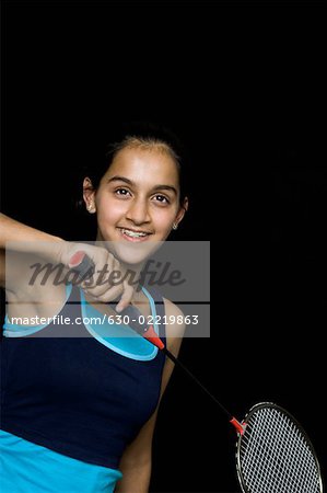 Teenage girl holding a badminton racket and smiling