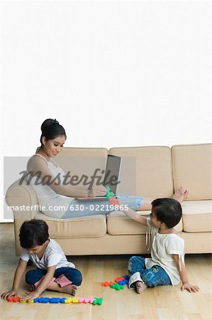 Jouets fille à sa mère et sa sœur jouant avec des jouets près d'eux