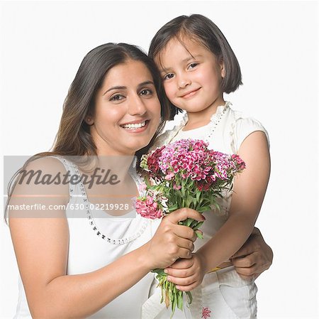 Portrait of a young woman with her daughter holding a bunch of flowers