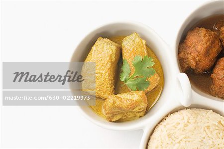 Nahaufnahme von gekochtem Reis und Frikadellen mit Fisch-Curry in Schüsseln serviert