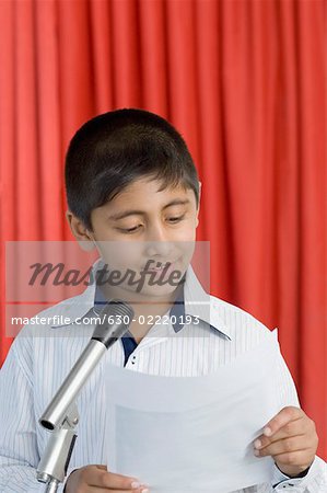 Junge hält eine Rede auf einer Bühne