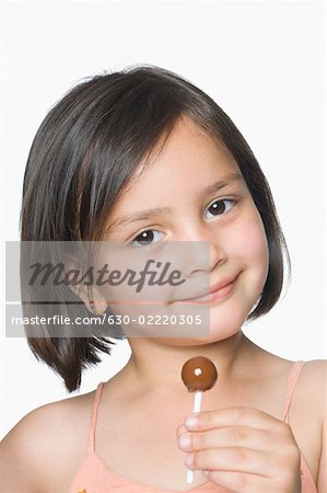 Portrait of a girl holding a lollipop and smirking