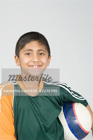 Portrait of a boy holding a football and smiling