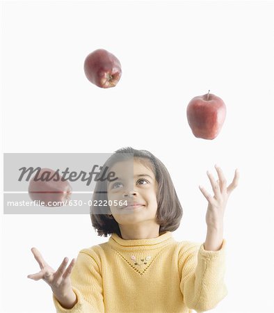 Girl juggling with apples