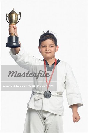 Portrait of a boy holding a trophy