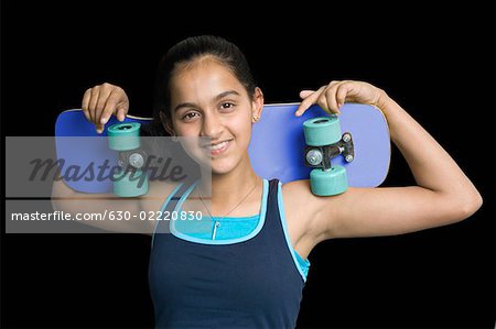 Portrait of a teenage girl holding a skateboard
