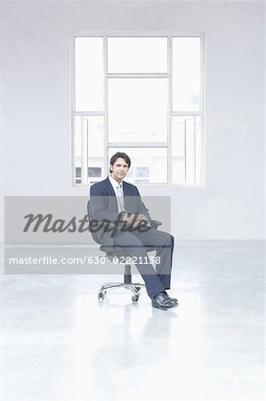Porträt eines Kaufmanns, sitzend auf einem Stuhl in einem Büro