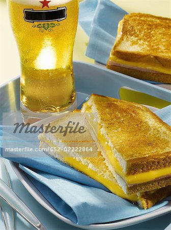 ham and cheddar toasted sandwich and glass of beer