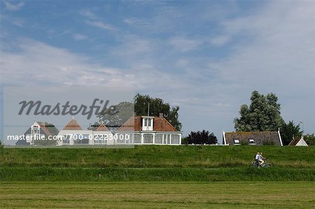 Radfahrer von Deich und Häuser, Edam, Nordholland, Niederlande