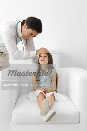 Front médecin de sexe masculin sentiment jeune patient, fille assise sur le fauteuil