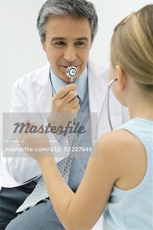 Pédiatre parler dans le stéthoscope, fille écoute