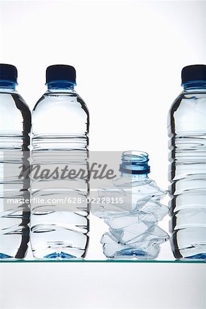 Swatted Kunststoff-Flasche zwischen gefüllten Plastikflaschen