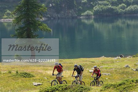 Drei Mountainbike-Fahrer, die Fahrt entlang der Ufer