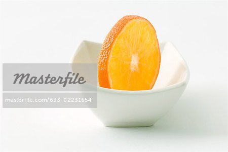 Orange slice in small dish, close-up