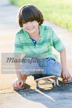 Portrait de garçon assis sur une planche à roulettes