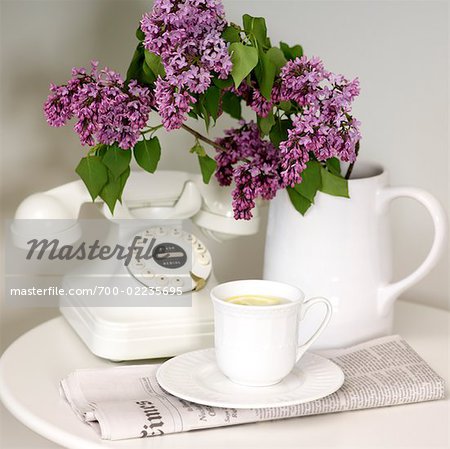 Lemon Tea, Vase of Lilacs, Telephone, and Newspaper on Table