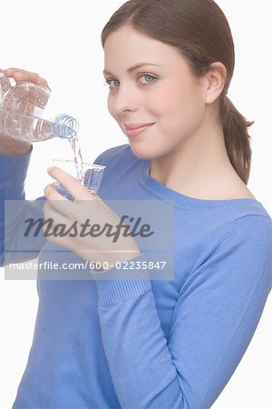 Woman Pouring Water from Bottle