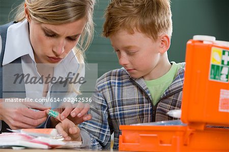 Teacher and boy with plaster on finger