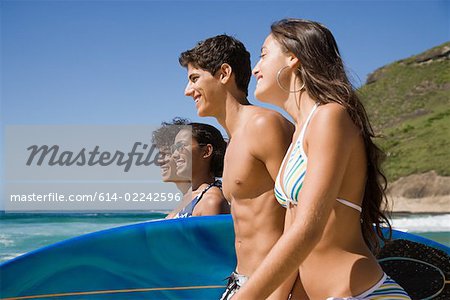 Teenagers carrying surfboards