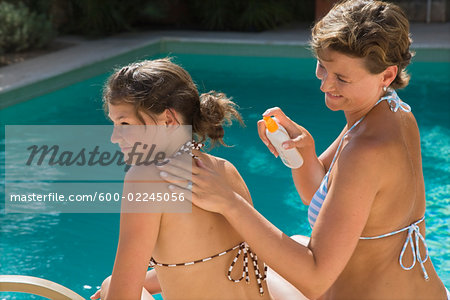 Mother Applying Sunscreen to Daughter's Back Mother Applying Sunscreen to Daughter's Back