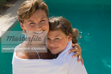 Mother and Daughter Standing by Swimming Pool, Wrapped in Towel