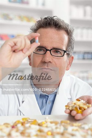 Pharmacist Looking at Pile of Pills