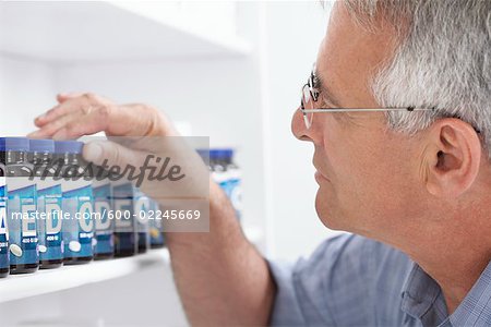 Man Looking at Selection of Vitamins