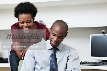 Woman Looking Over Businessman's Shoulder