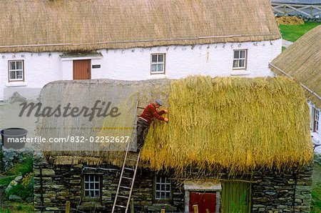 High angle view of a man thatching the roof, Folk Village, Glencolumbkille, Republic Of Ireland