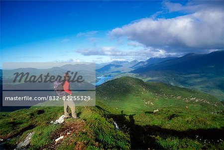 Macgillycuddy's Reeks from Torc Mountain, Killarney National Park County Kerry, Ireland; Hiker on mountain top Macgillycuddy's Reeks from Torc Mountain, Killarney National Park County Kerry, Ireland; Hiker on mountain top