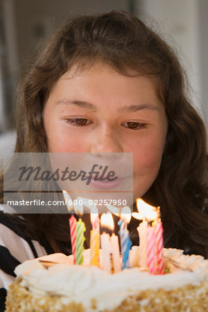 Girl Blowing Out Candles on Birthday Cake