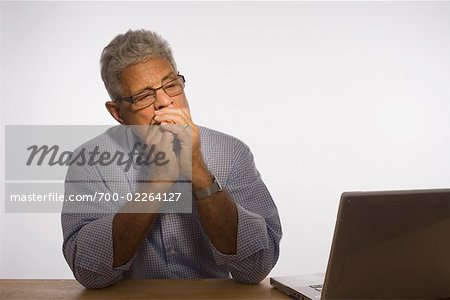 Portrait d'homme regardant ordinateur portable