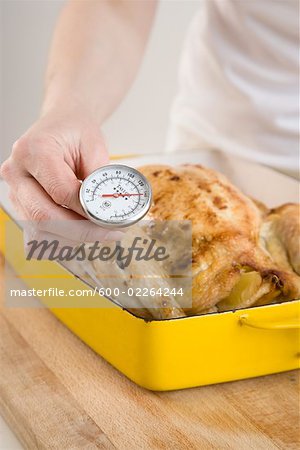 Woman Checking Temperature of Chicken