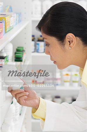 Pharmacien pilules en regardant sur l'étagère