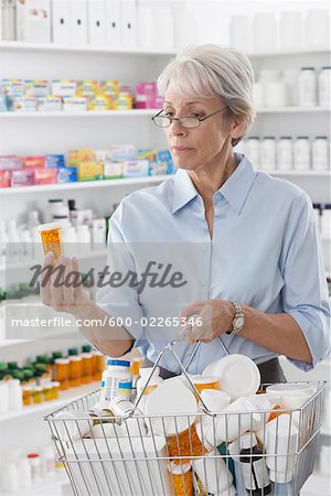 Customer in Drug Store Looking at Bottles of Pills