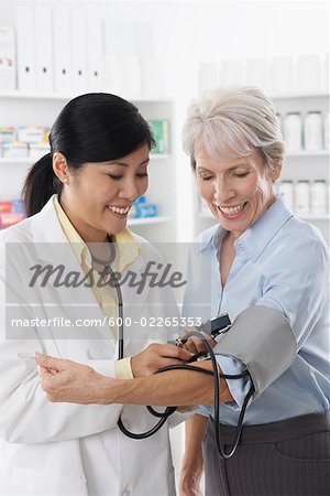 Pharmacist Checking Client's Bloodpressure